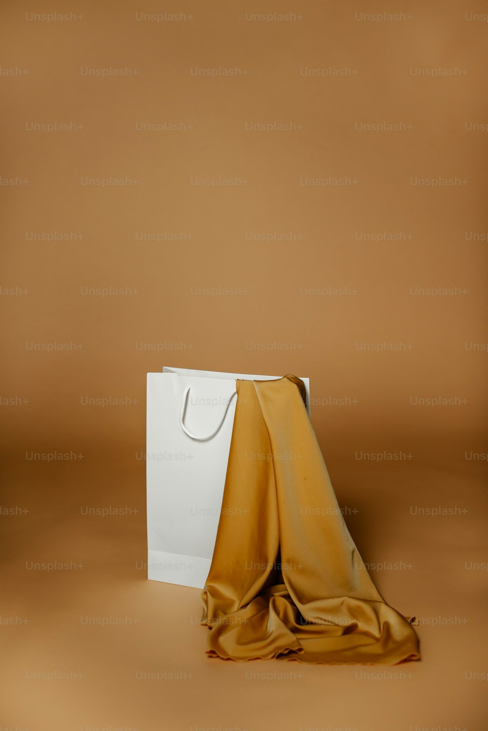 a white bag with a gold cloth on top of it