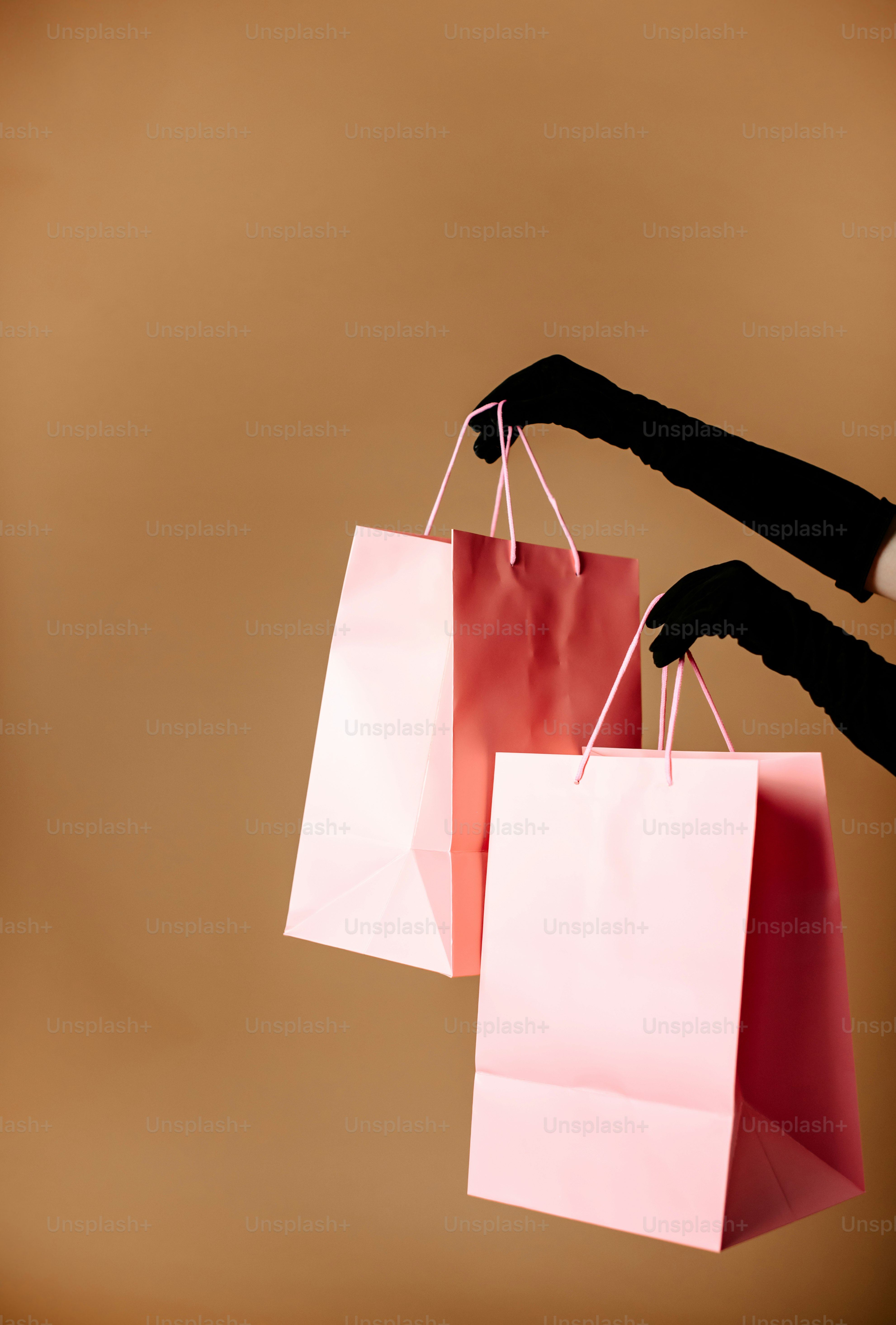 eine Person, die drei Einkaufstüten in der Hand hält