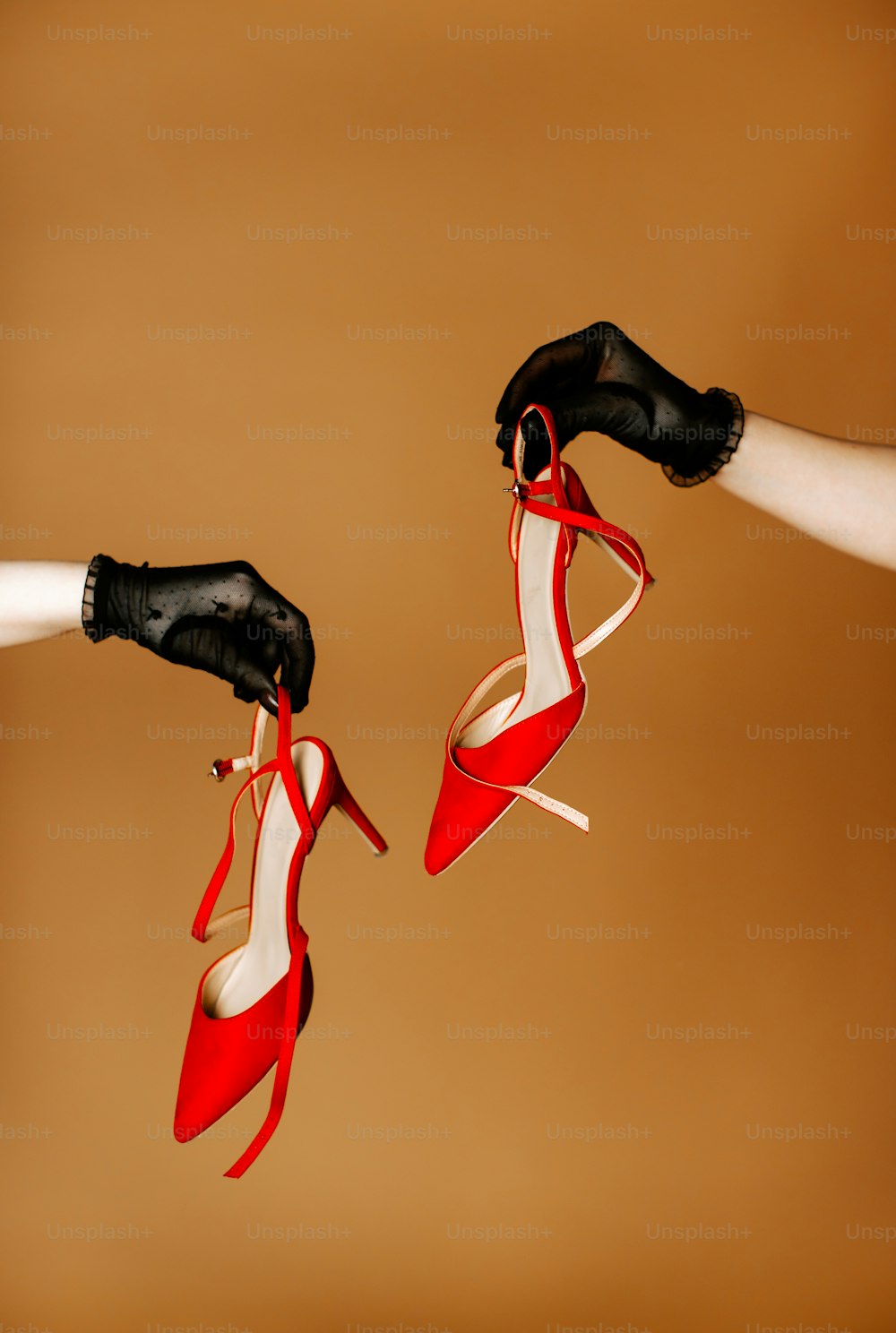 um par de sapatos de mulher sendo segurado por duas mãos