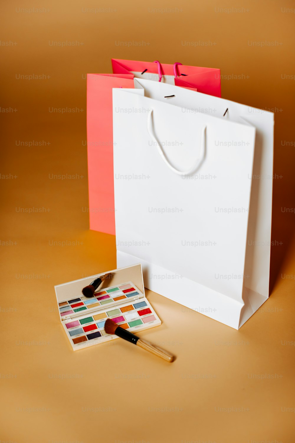a white shopping bag with a brush next to it