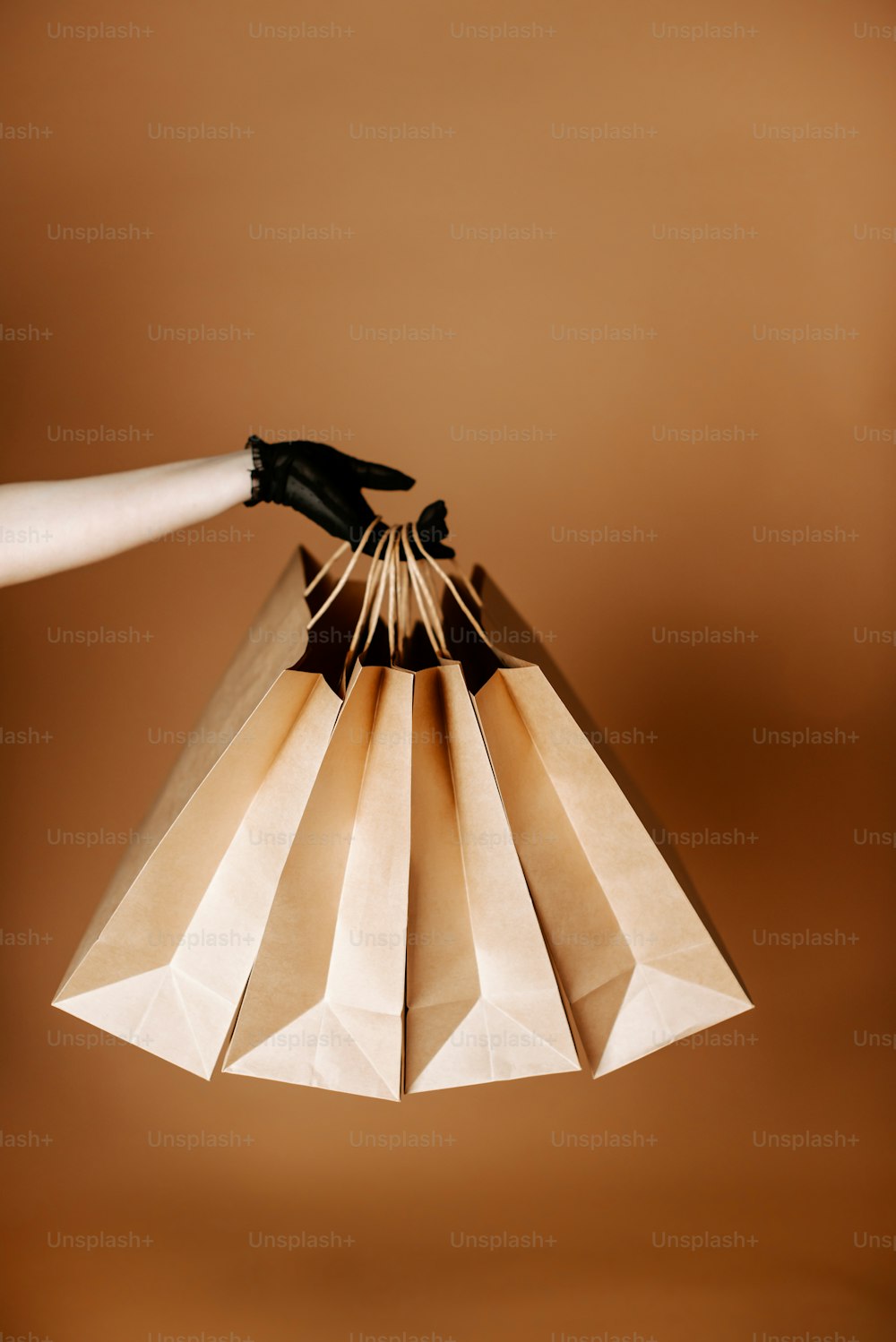 uma mão segurando um saco de papel com um par de luvas sobre ele