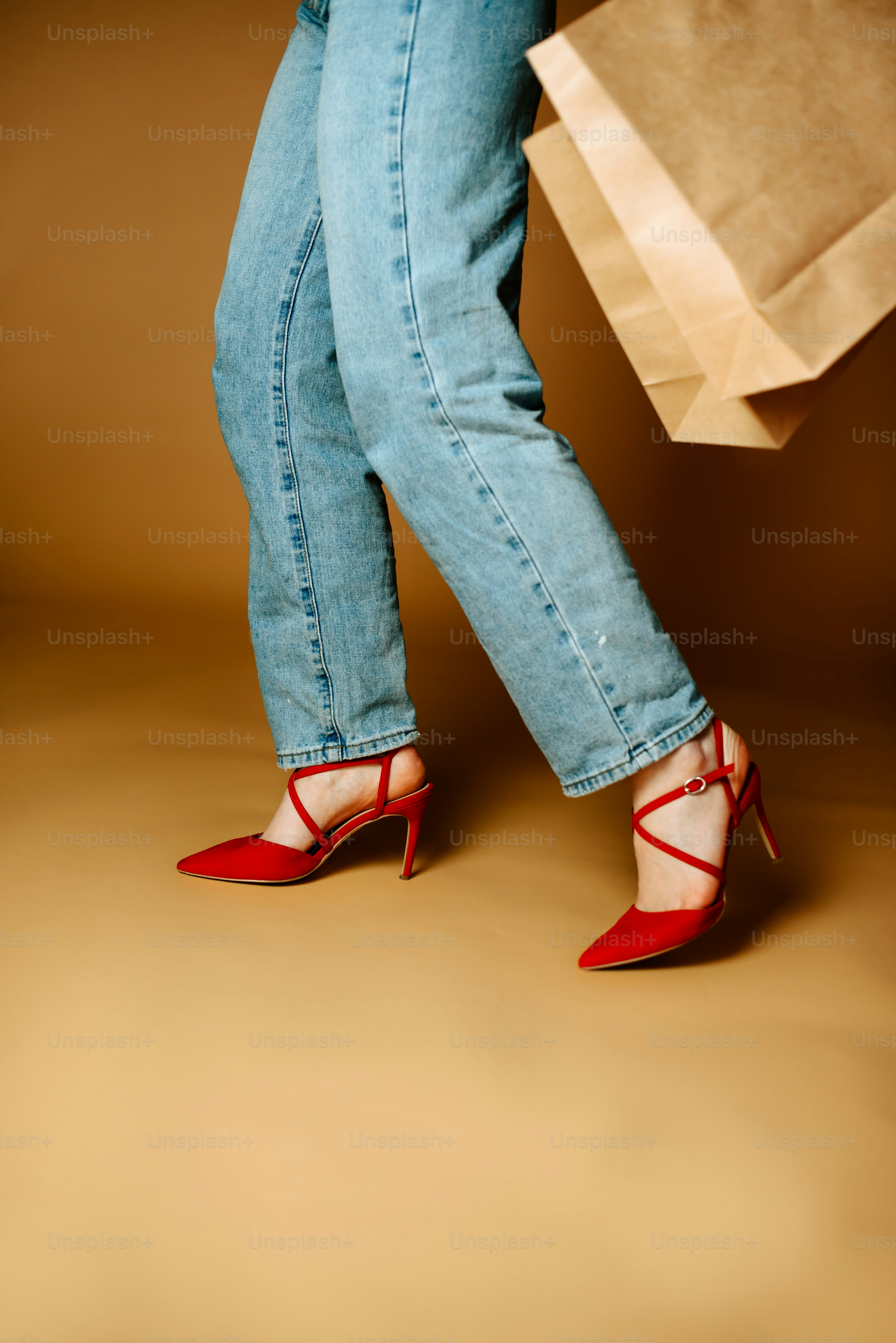les jambes d’une femme en talons hauts tenant un sac à provisions