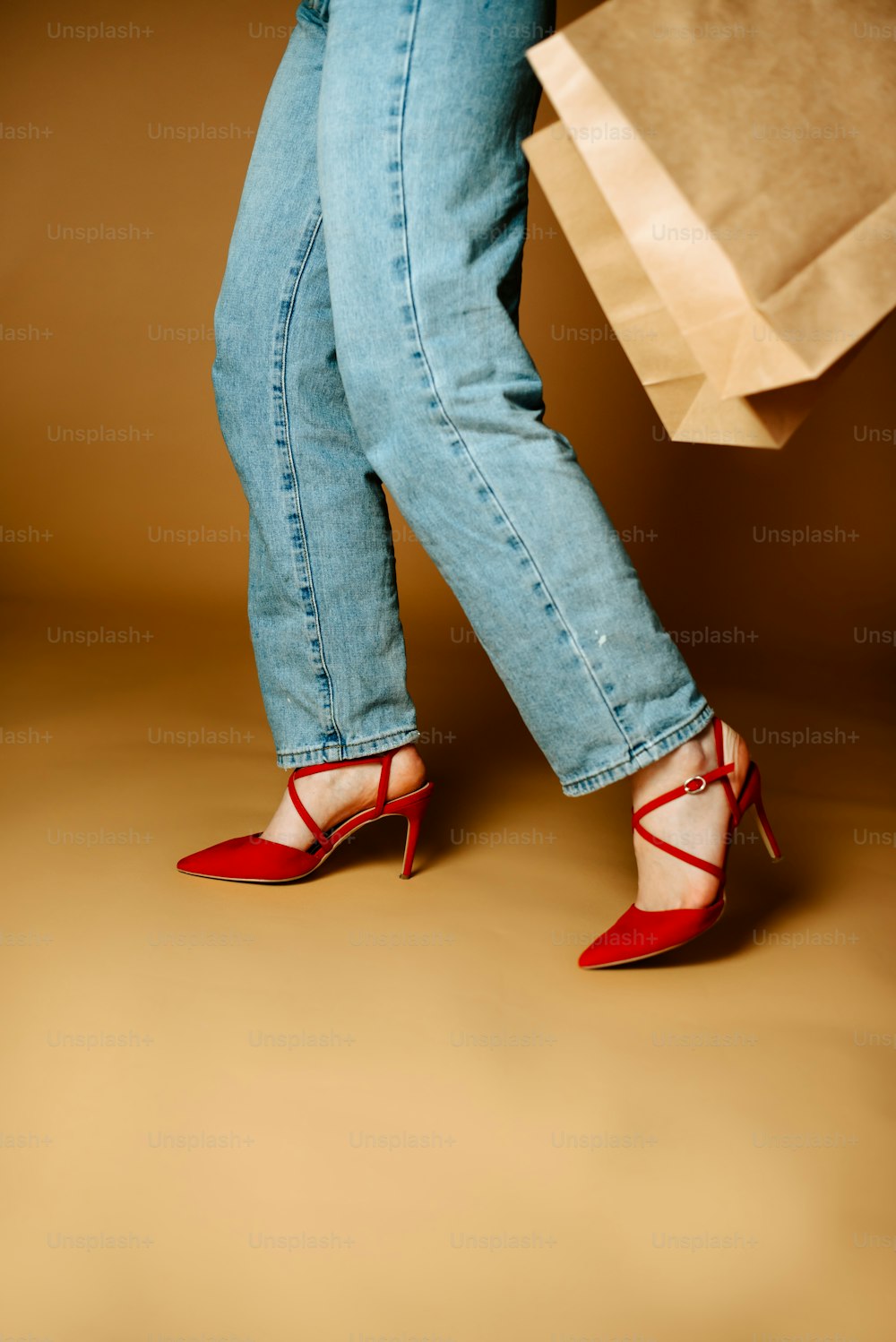 as pernas de uma mulher em saltos altos segurando uma sacola de compras