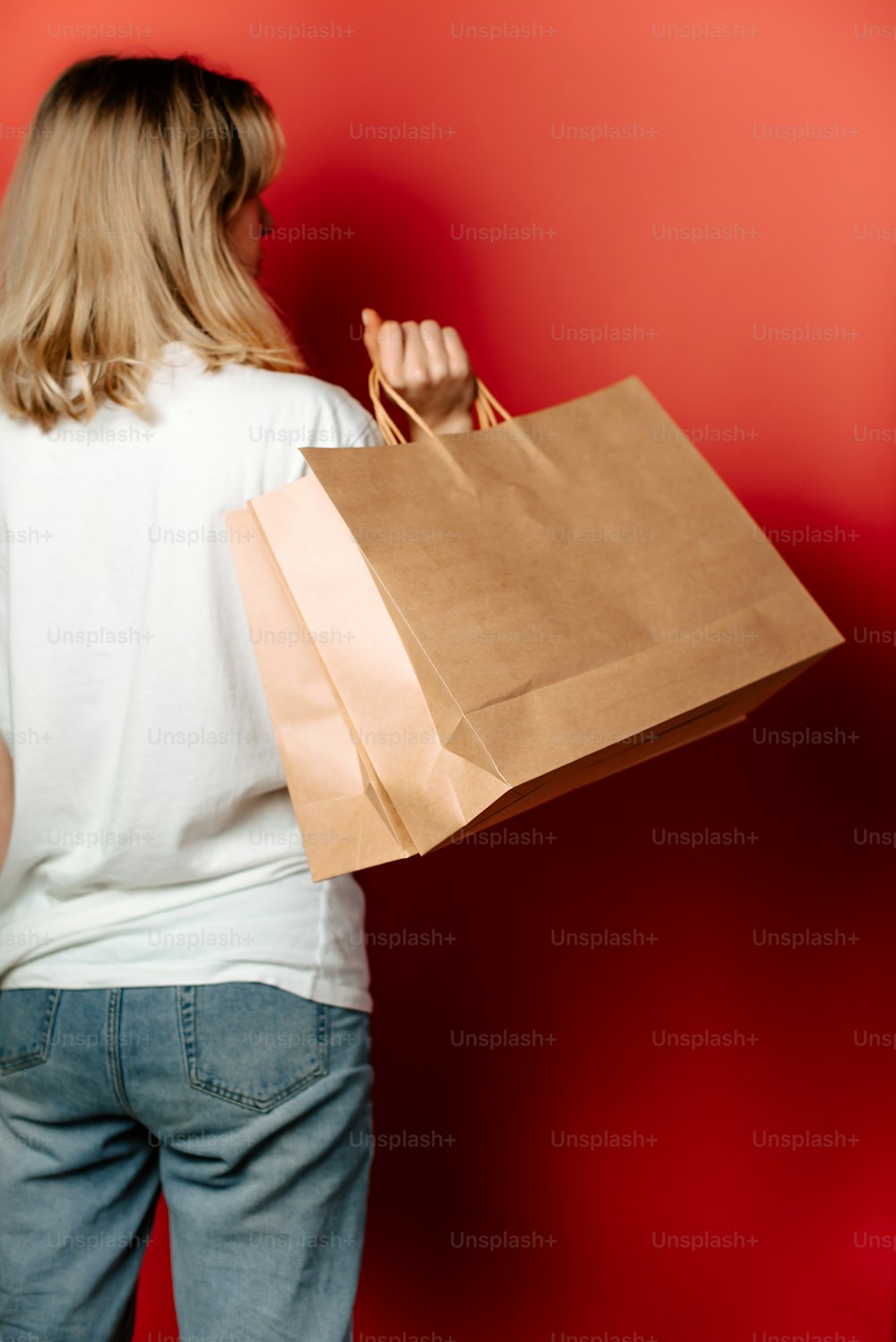 Una mujer que lleva una bolsa de papel marrón