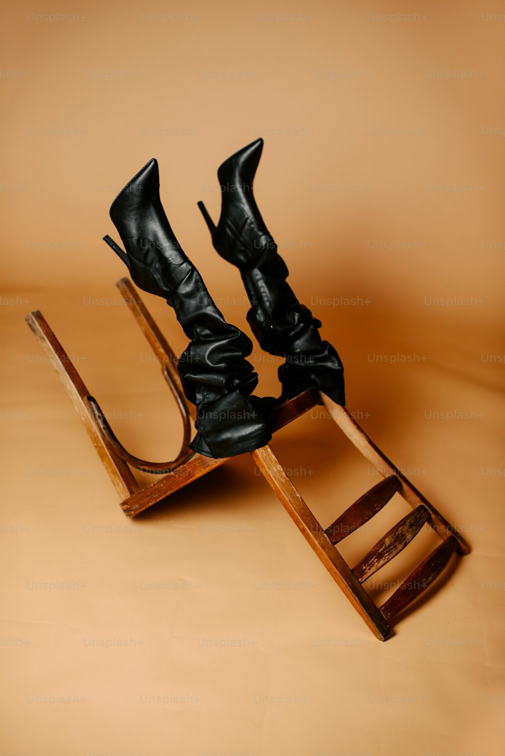 a pair of black high heeled shoes sitting on top of a wooden sled