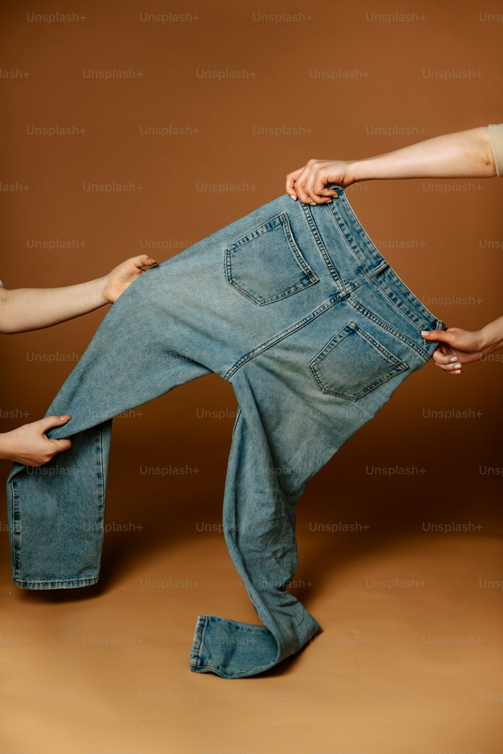 a pair of hands holding a pair of jeans