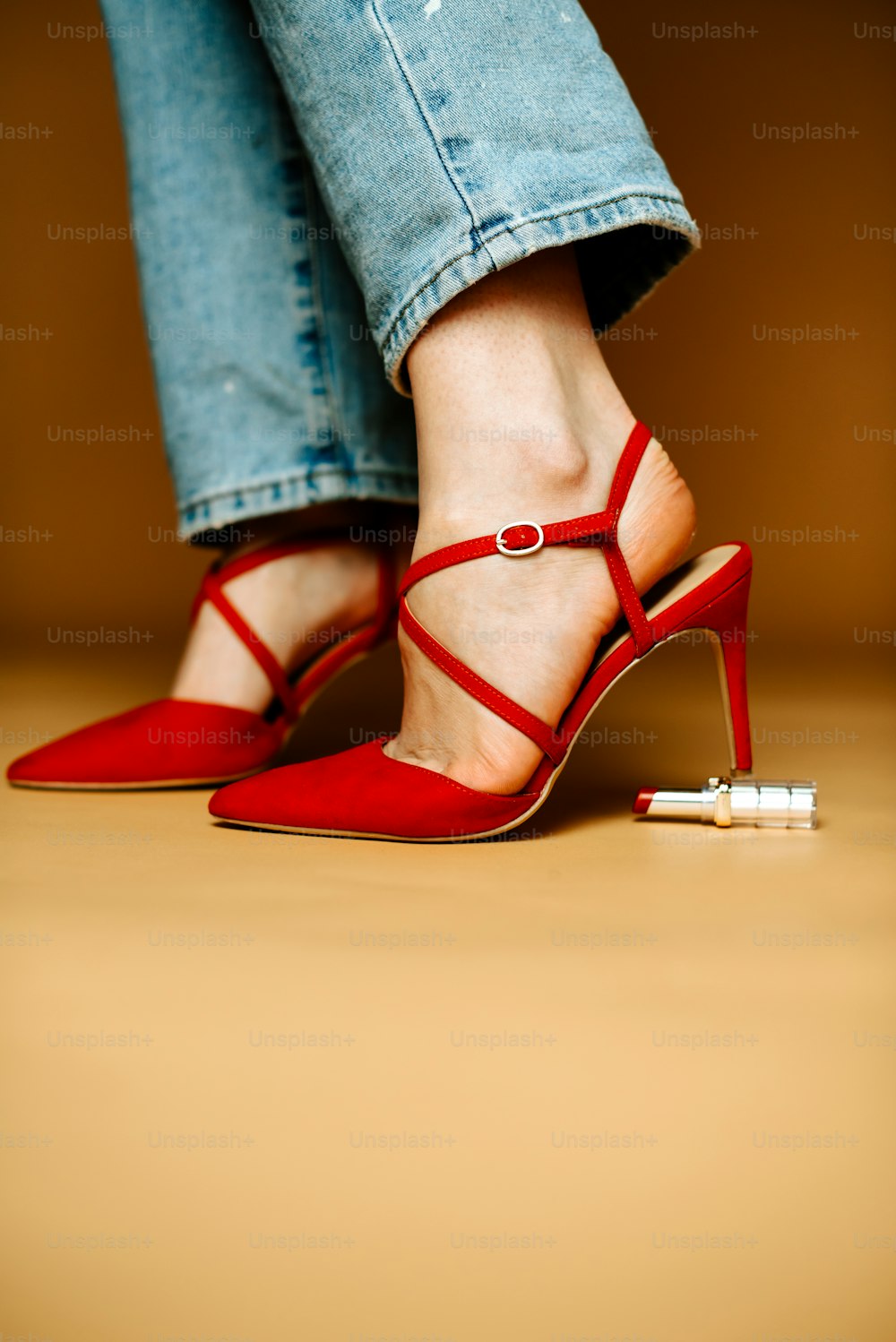 Eine Frau in roten High Heels steht auf einem Holzboden