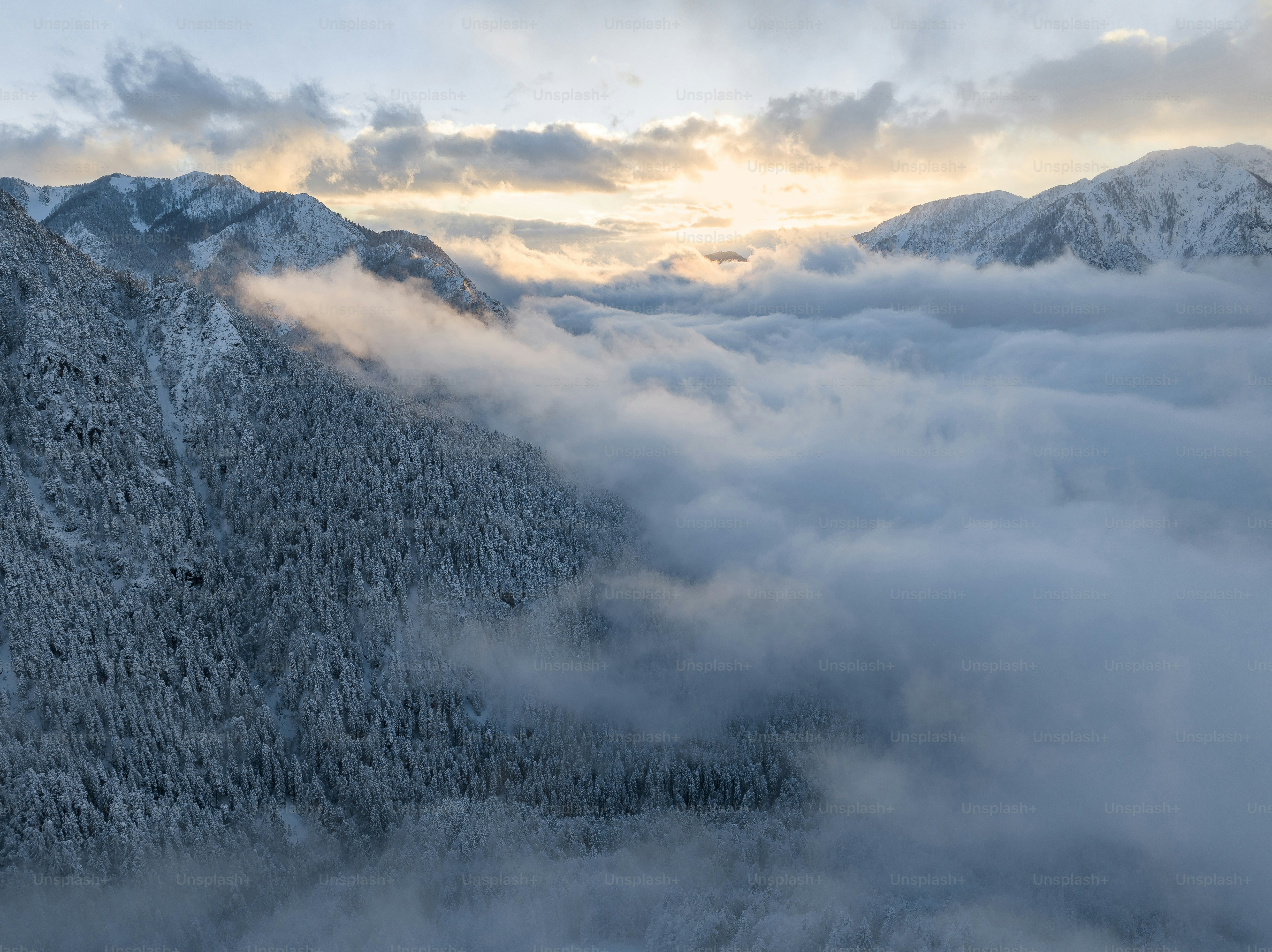 A mountain covered in snow and clouds under a cloudy sky photo – Valley ...