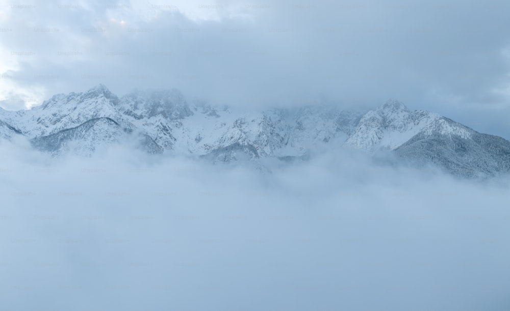 흐린 하늘 아래 눈과 구름으로 뒤덮인 산