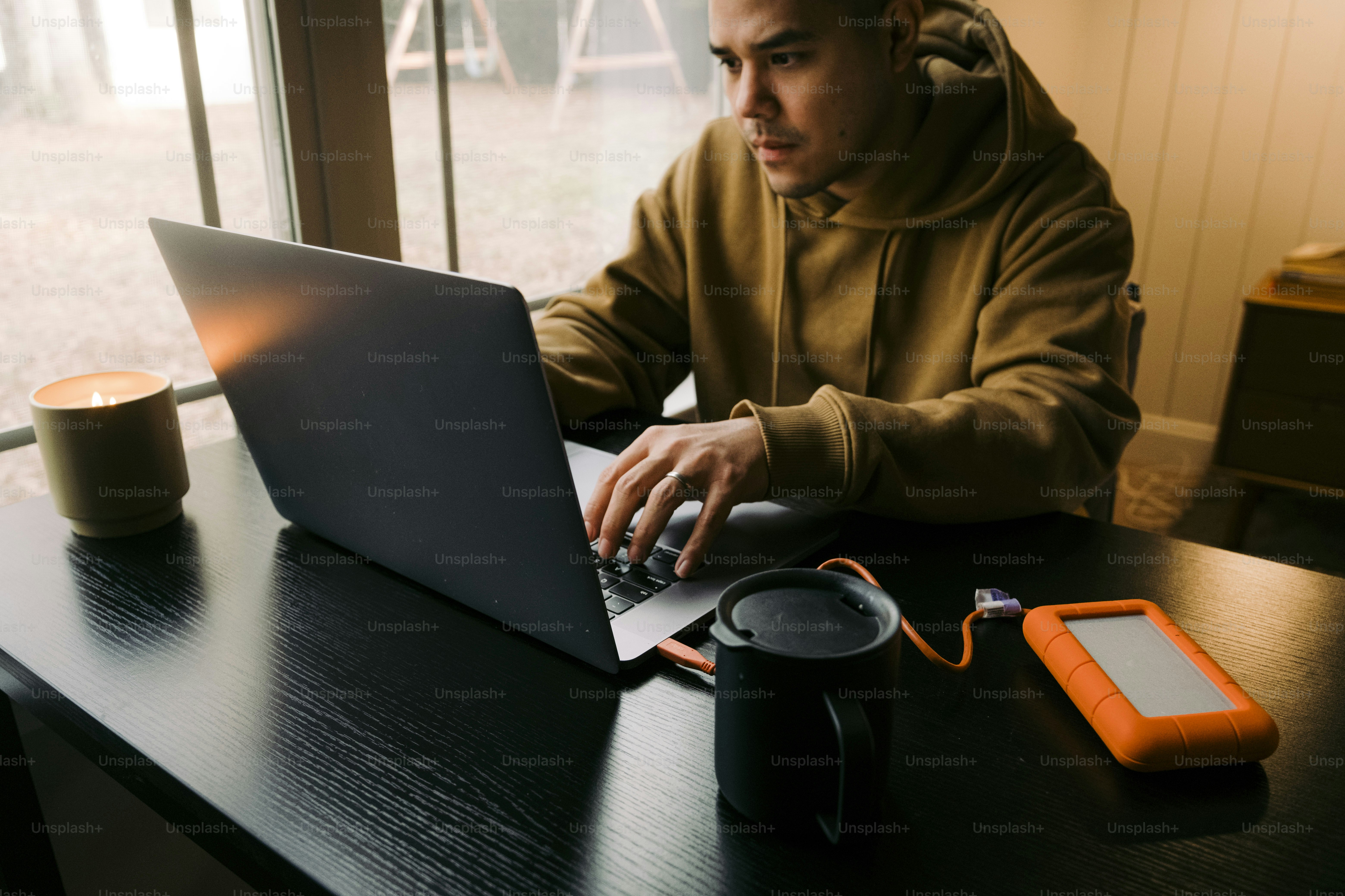a man sitting at a table using a laptop computer