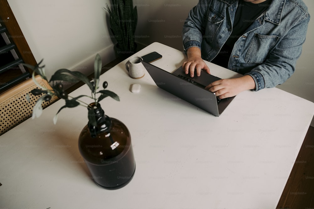 a man sitting at a table using a laptop