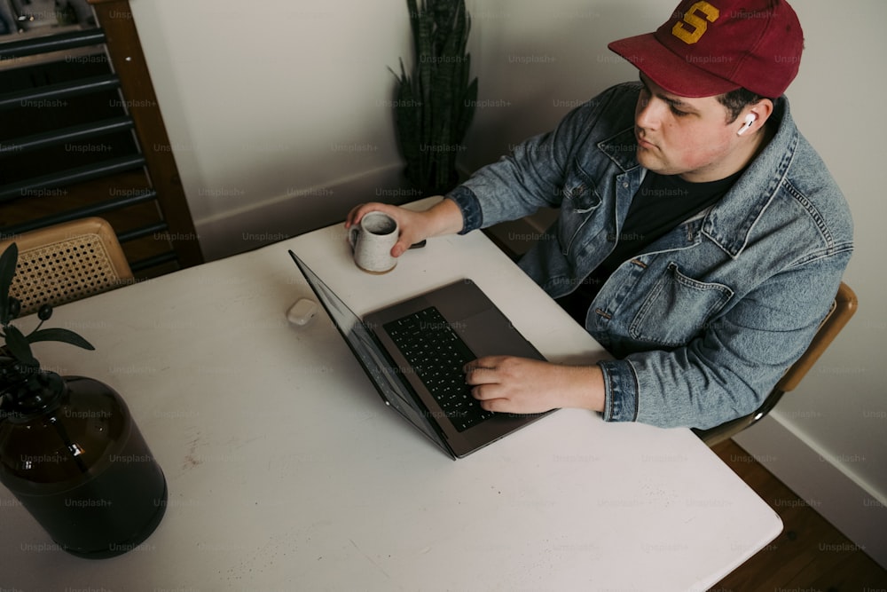 a man sitting at a table using a laptop computer