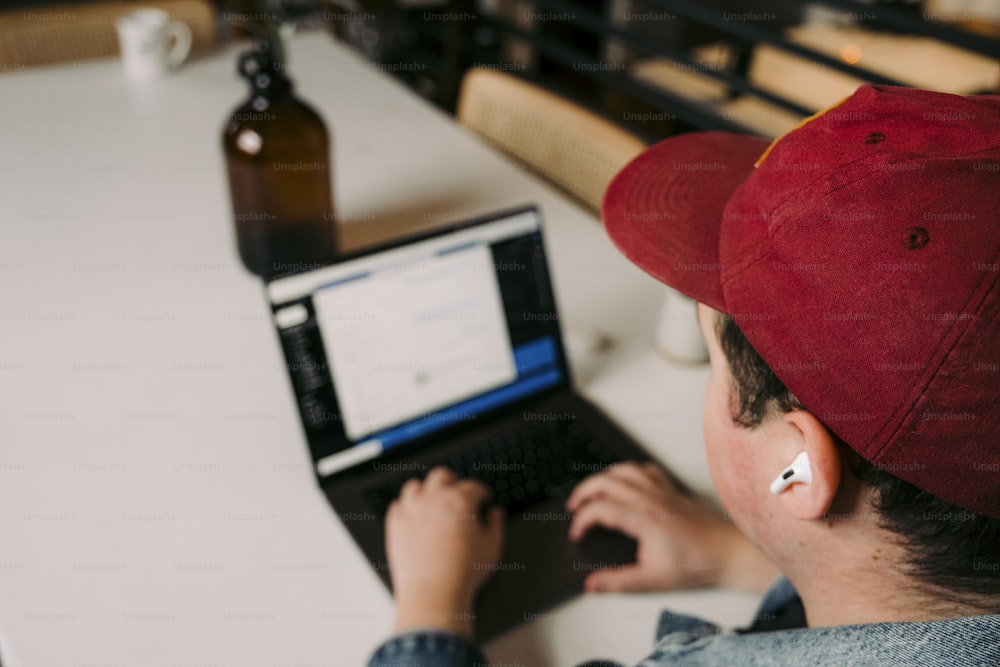 a person sitting at a table with a laptop