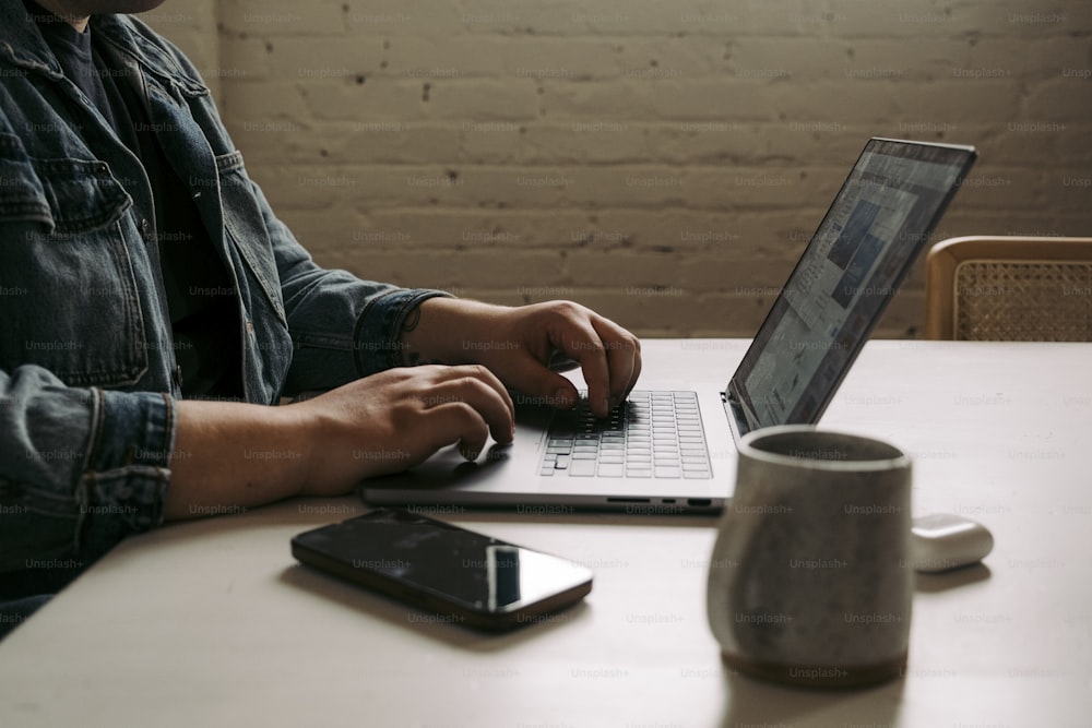 a man sitting at a table using a laptop computer