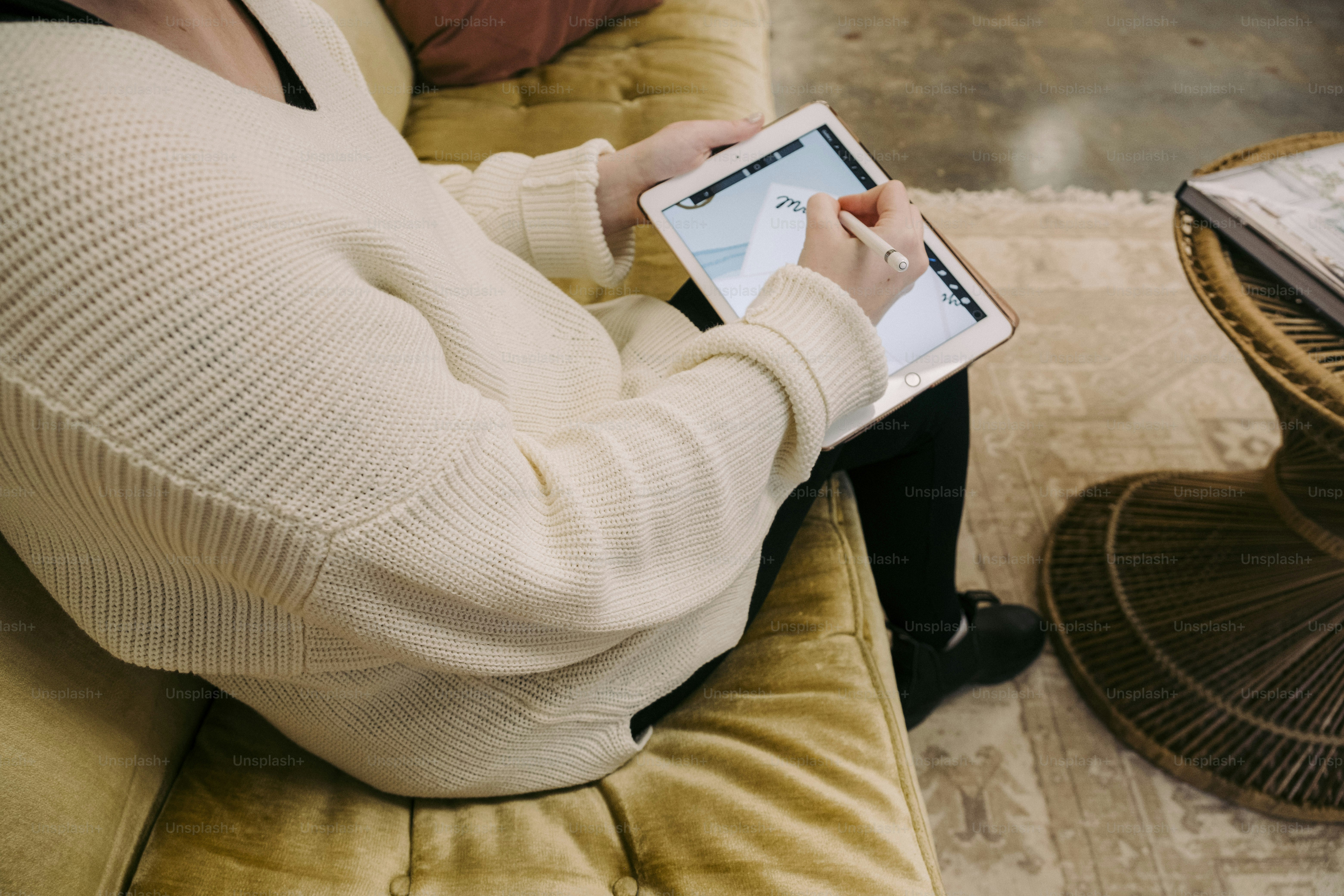 a person sitting on a couch using a tablet