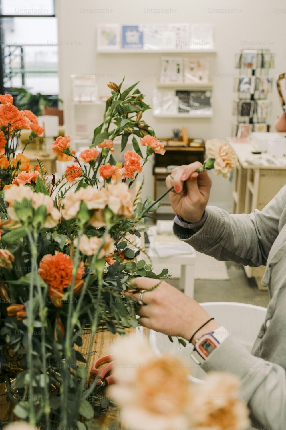 a woman is arranging flowers in a vase