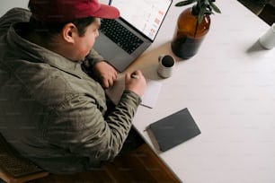 a man sitting at a desk working on a laptop