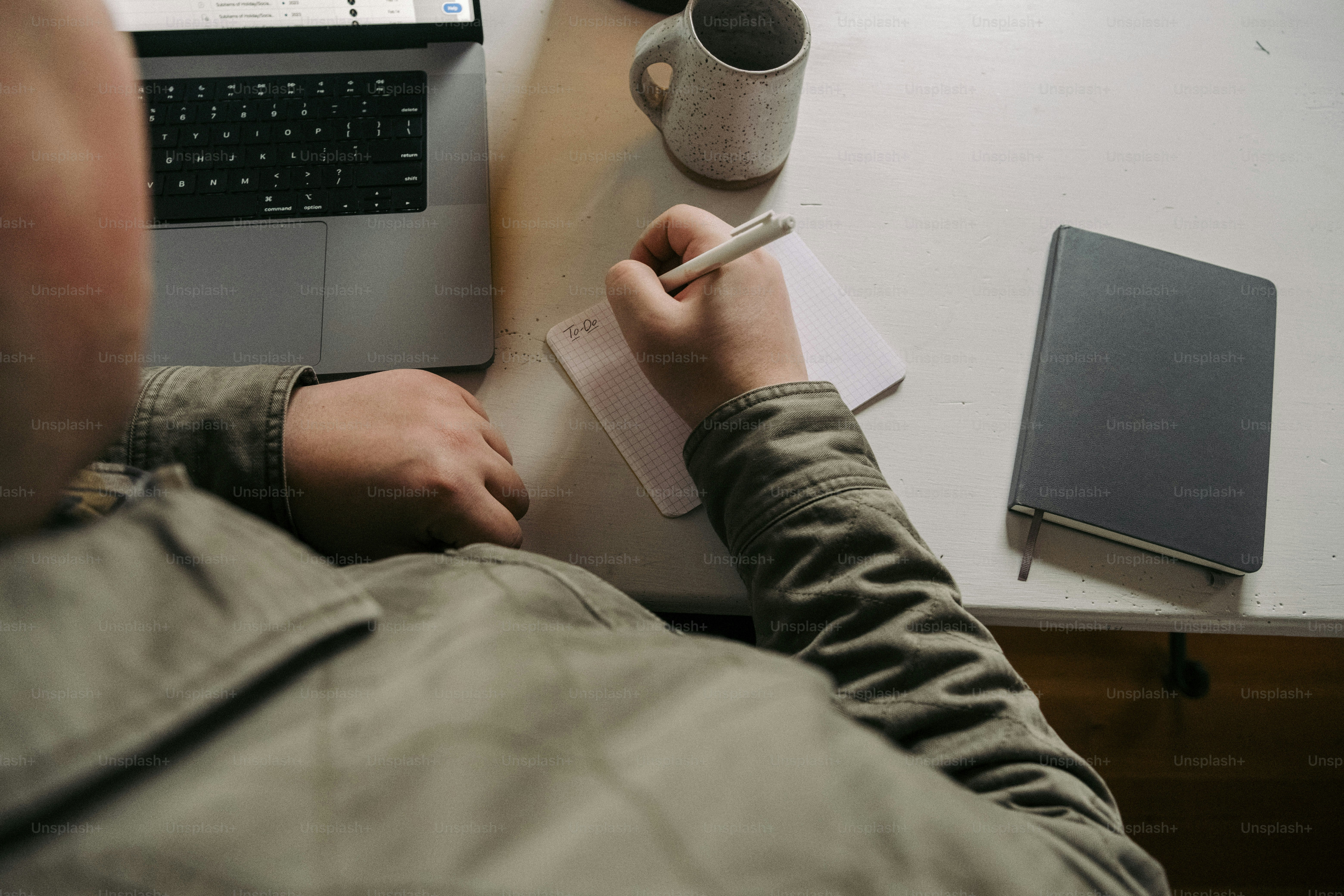 a man sitting at a desk writing on a piece of paper