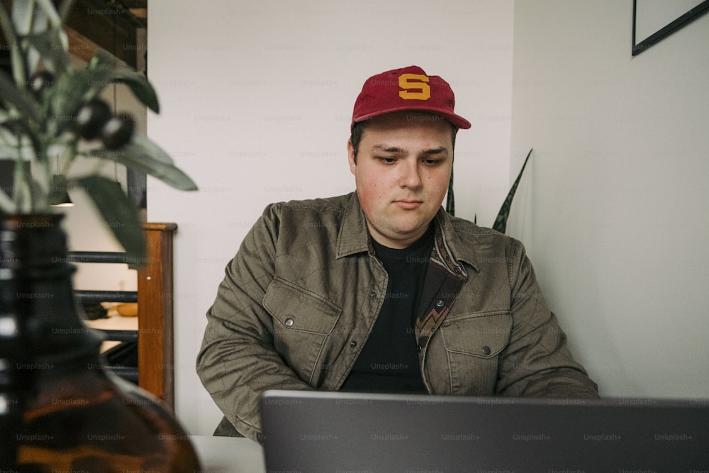 Un hombre sentado en un escritorio con una computadora portátil