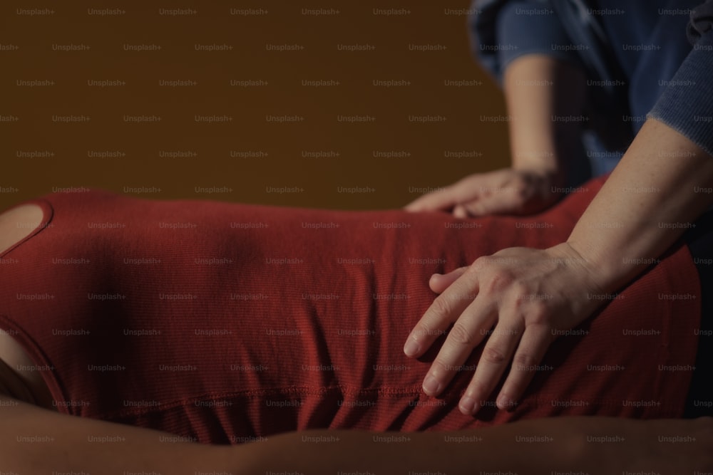 Eine Frau, die eine Rückenmassage von einem Massagegerät bekommt