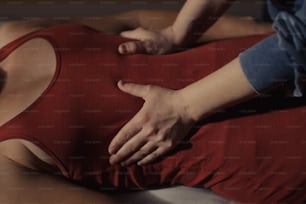 a woman in a red tank top laying on a bed