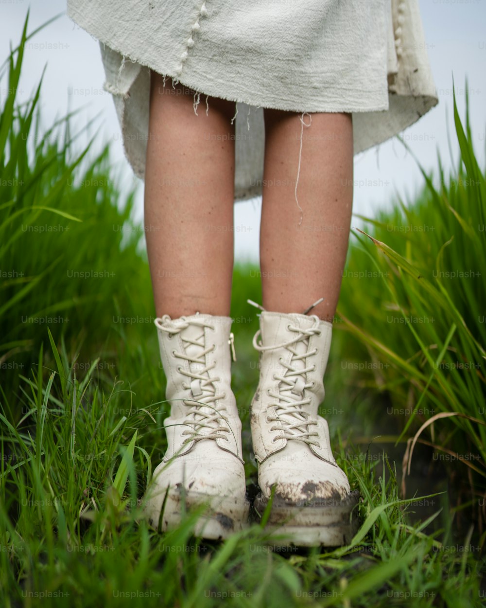 a close up of a person wearing white boots