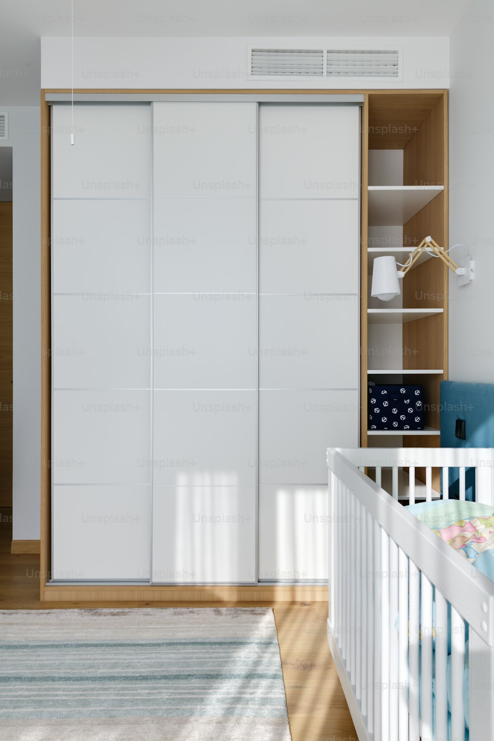 una habitación para bebés con una cuna y un armario blanco