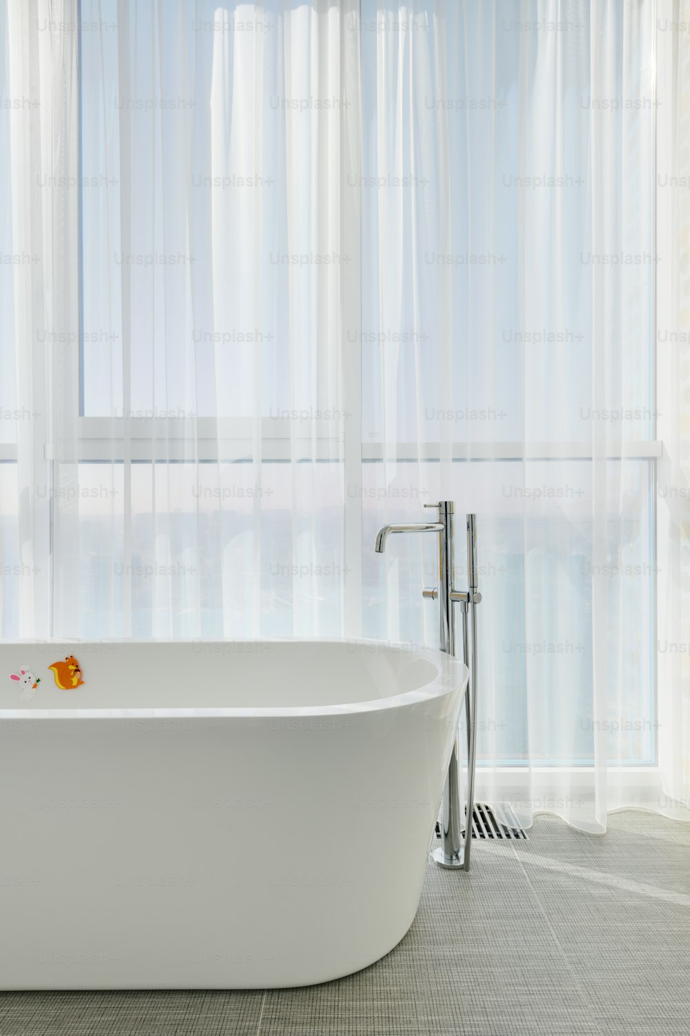 una vasca da bagno bianca seduta in un bagno accanto a una finestra