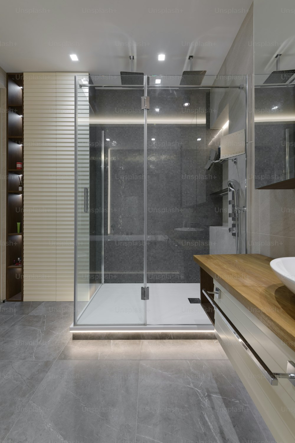 un cuarto de baño con ducha a ras de suelo junto a un lavabo