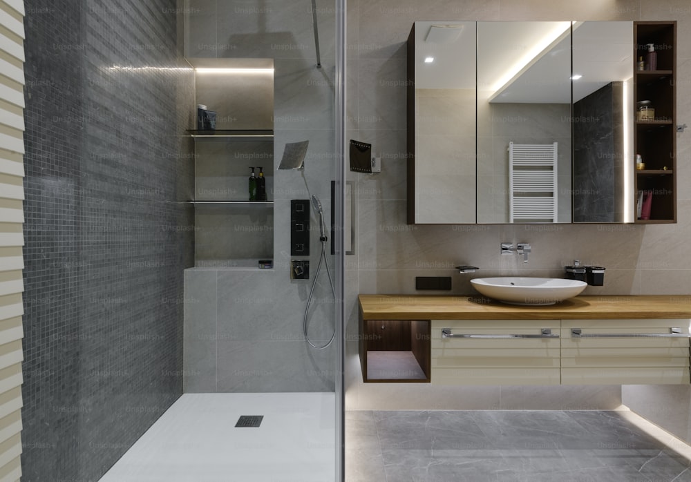 une salle de bain avec lavabo, miroir et cabine de douche