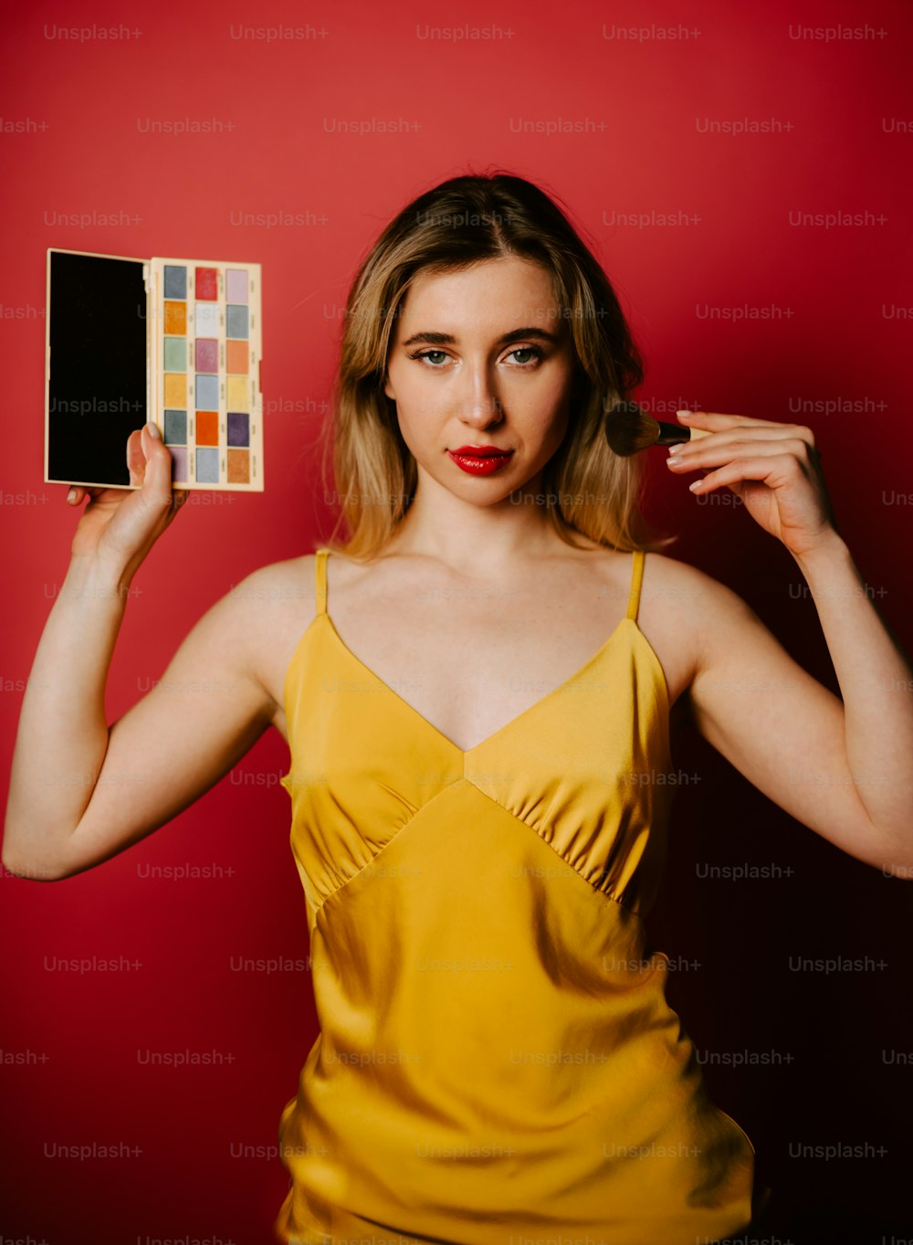 a woman in a yellow dress holding up a color swatter