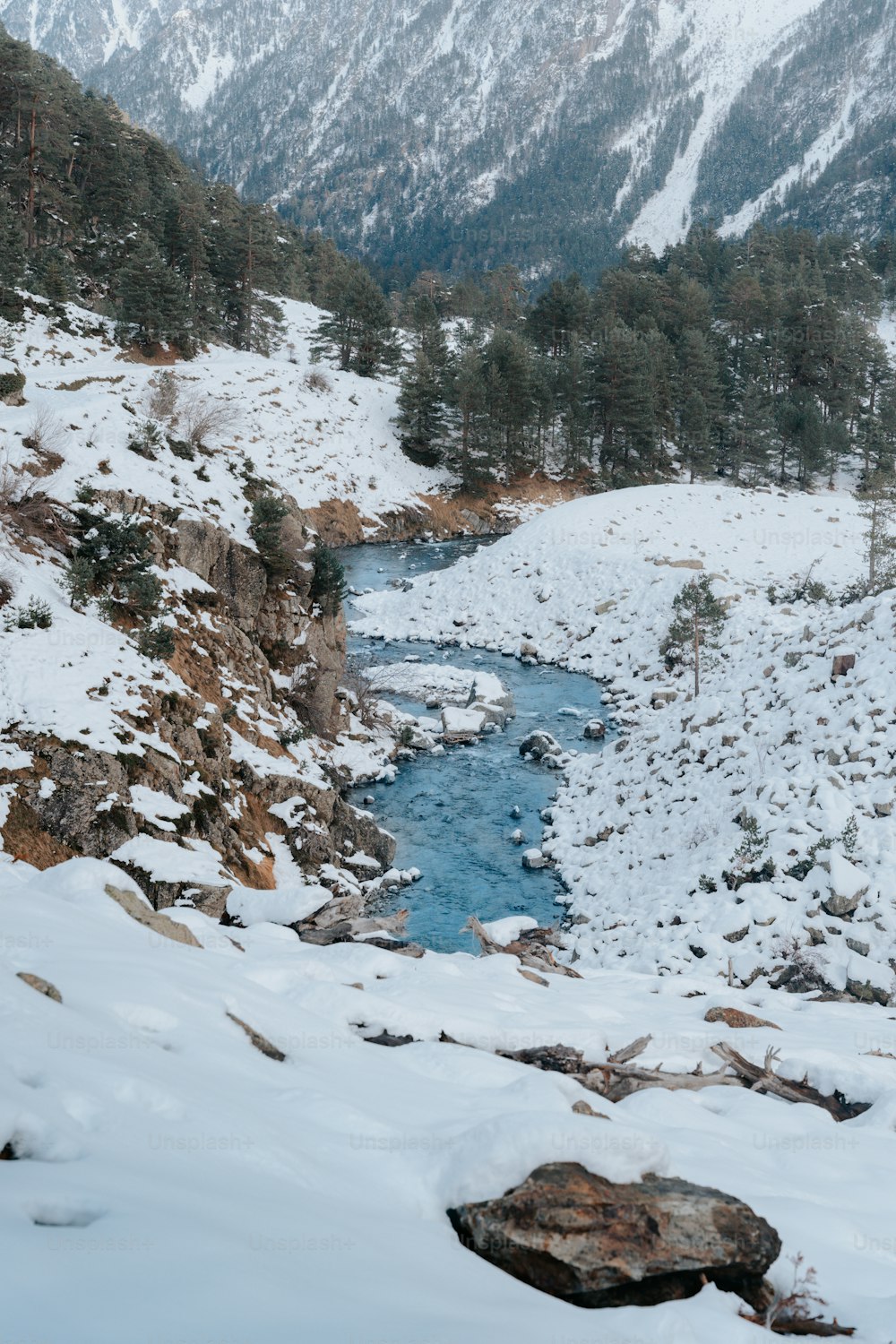 Ein Fluss, der durch ein schneebedecktes Tal fließt