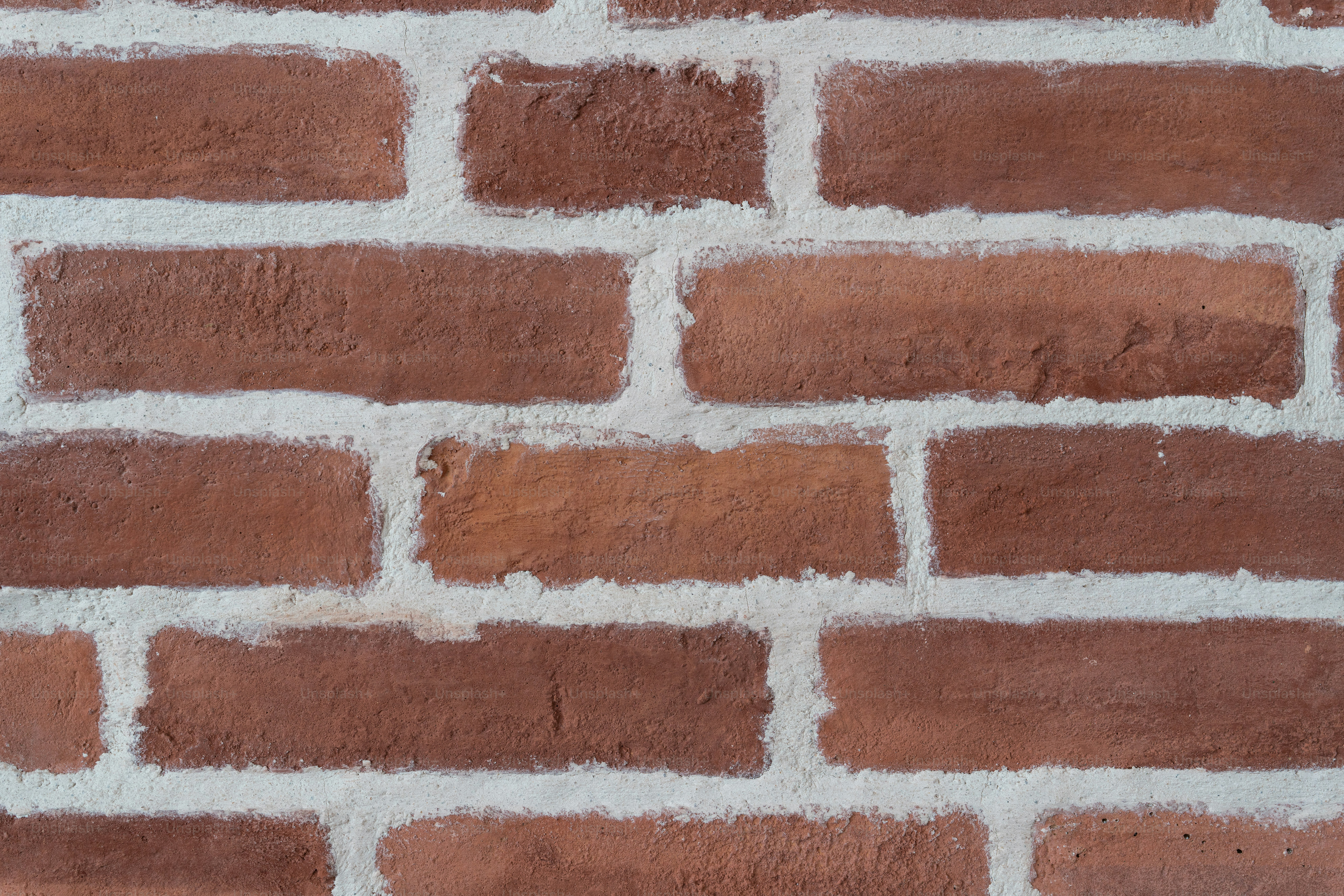 a close up of a brick wall with white paint