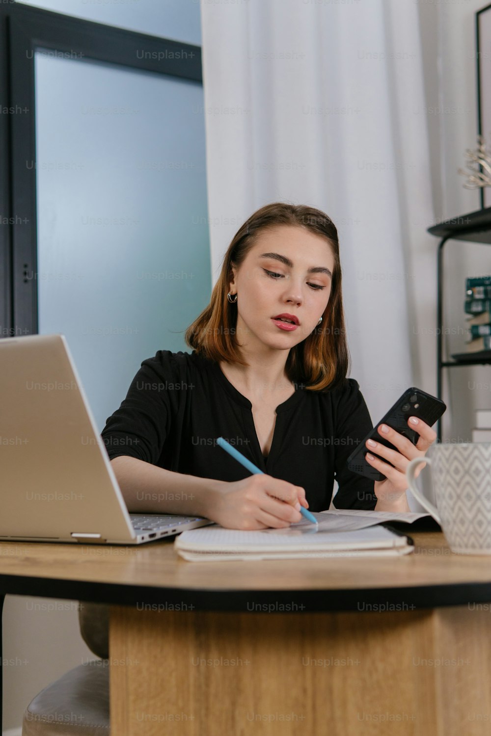 a woman sitting at a desk using a cell phone