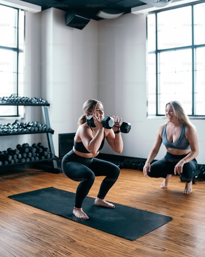 A woman holding a pair of dumbs in a gym photo – Strenght Image on Unsplash