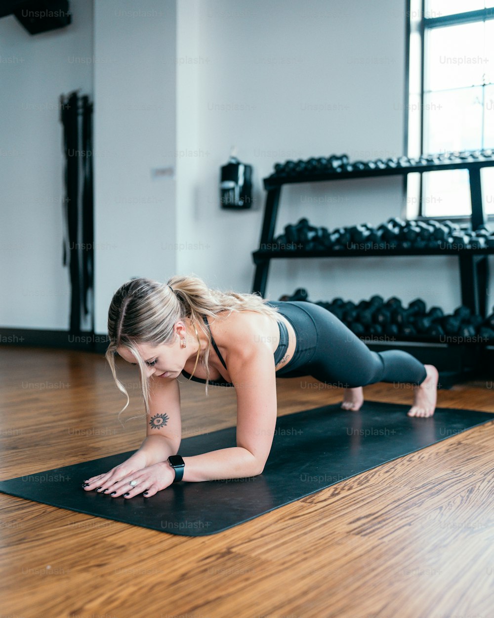 a woman is doing a push up on a yoga mat