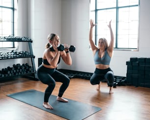 a couple of women standing on top of a yoga mat