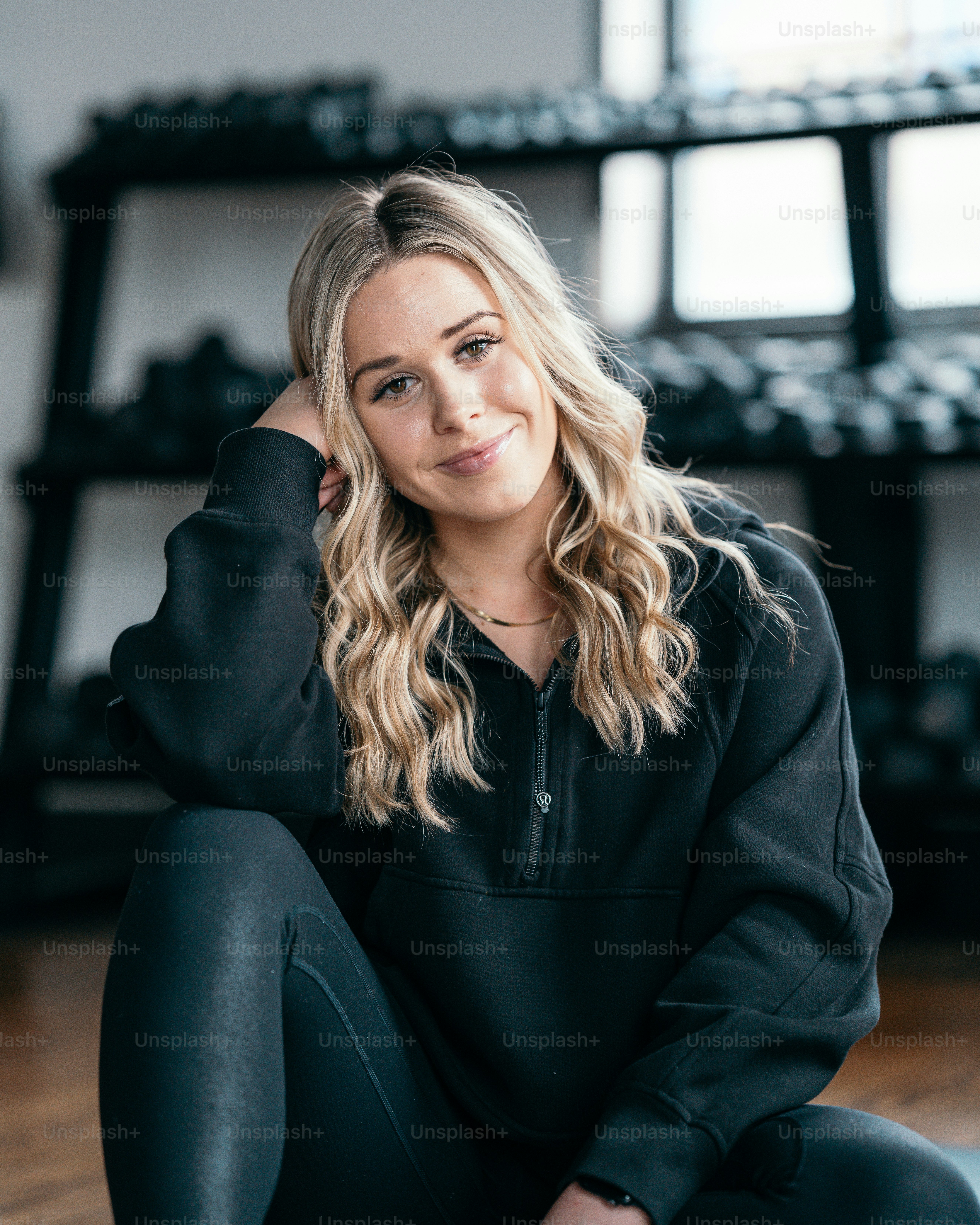 a woman sitting on the floor with her hand on her head