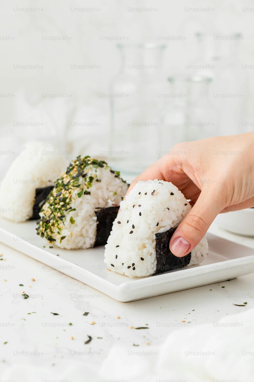 a person is picking up a piece of sushi
