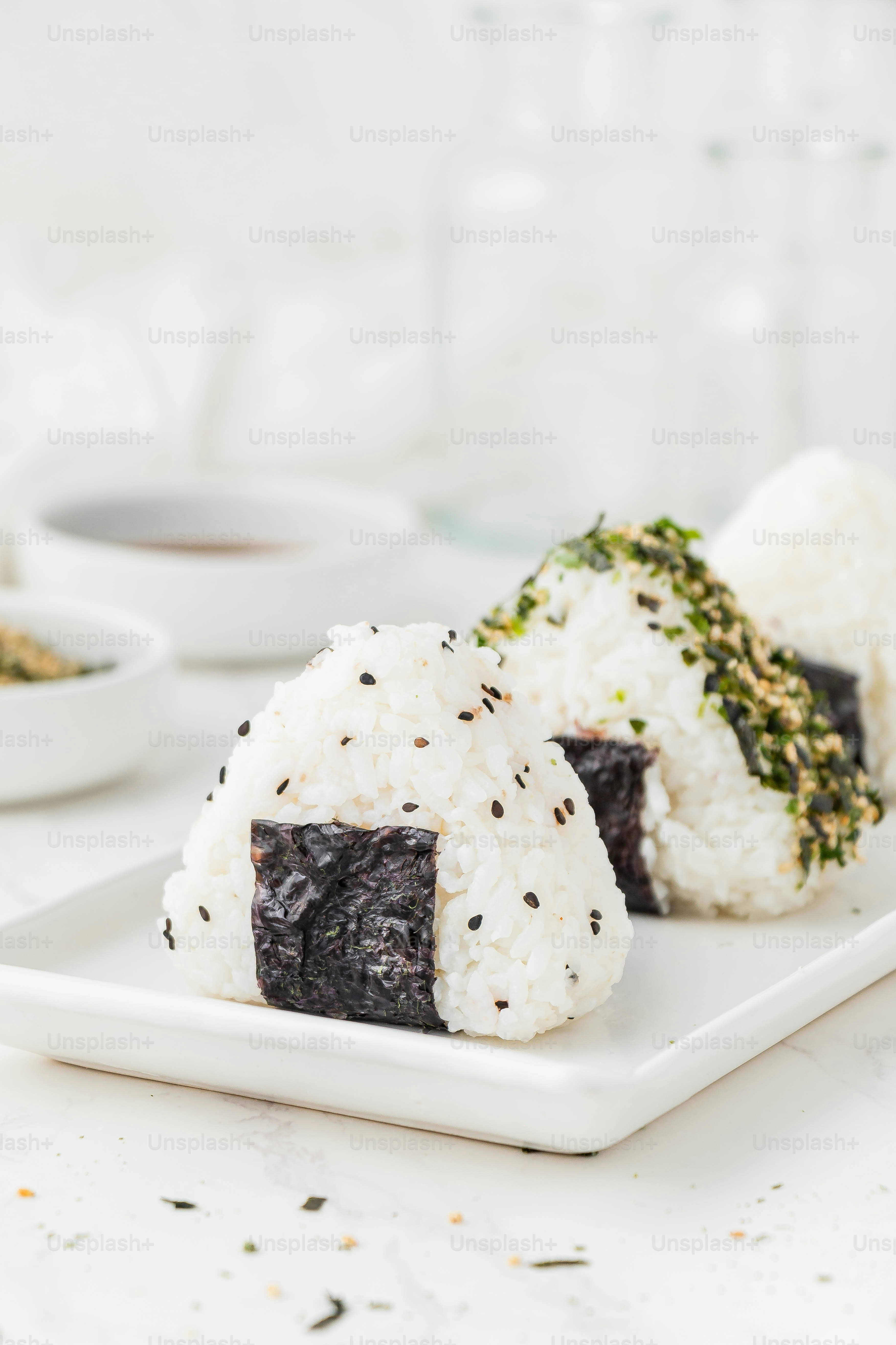 Un plato blanco cubierto con sushi y arroz