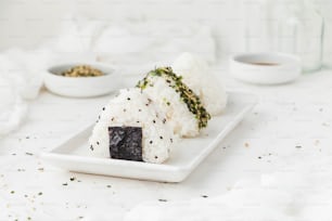 um prato branco coberto com sushi e arroz