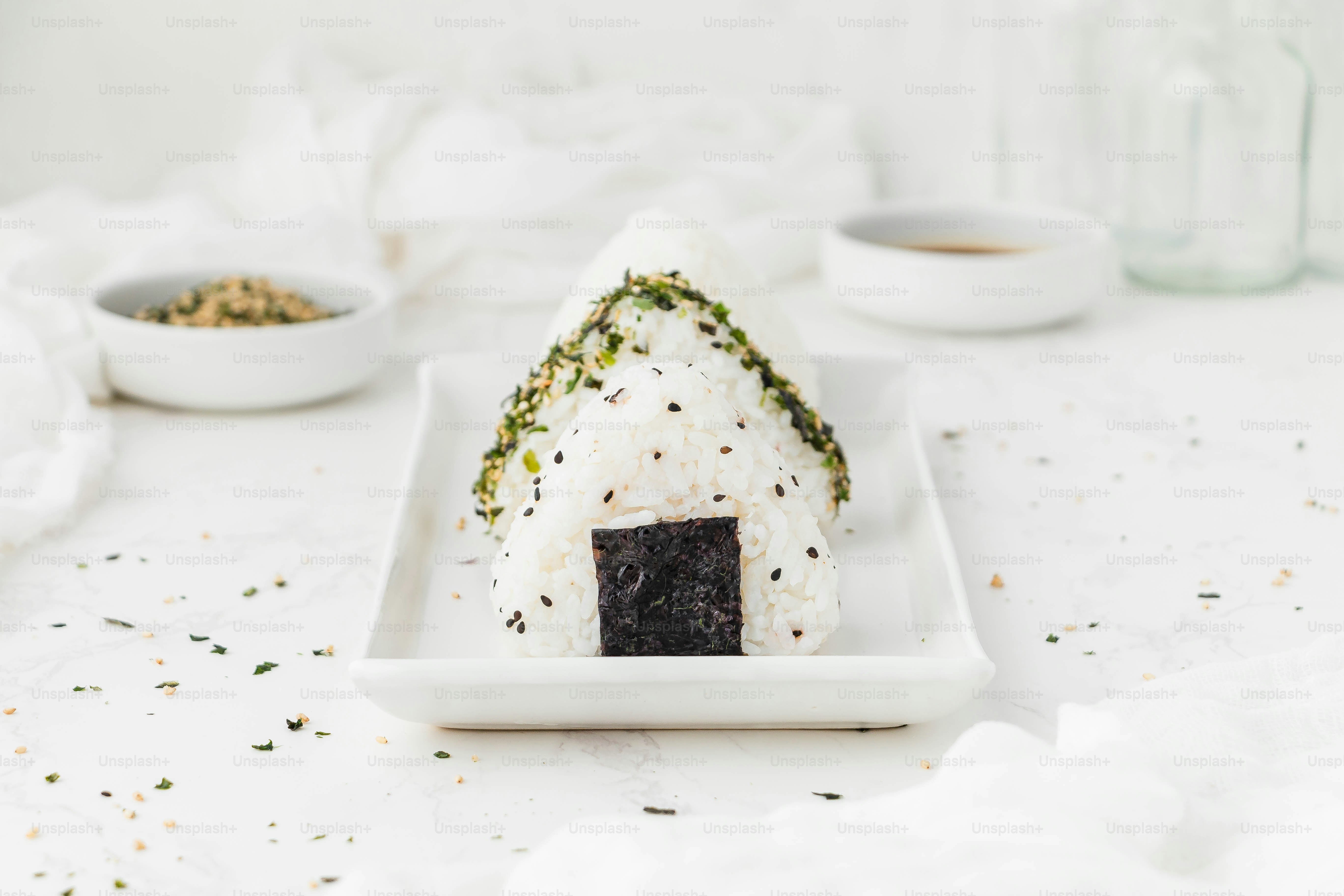 Un plato blanco cubierto con sushi y arroz