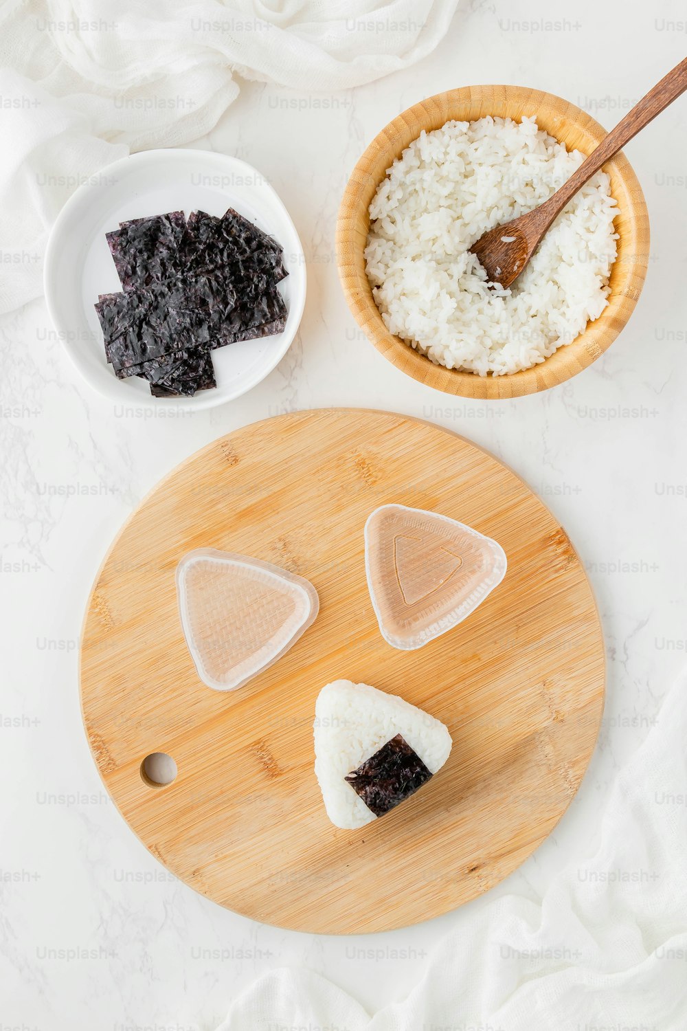 a cutting board topped with slices of cake next to a bowl of rice
