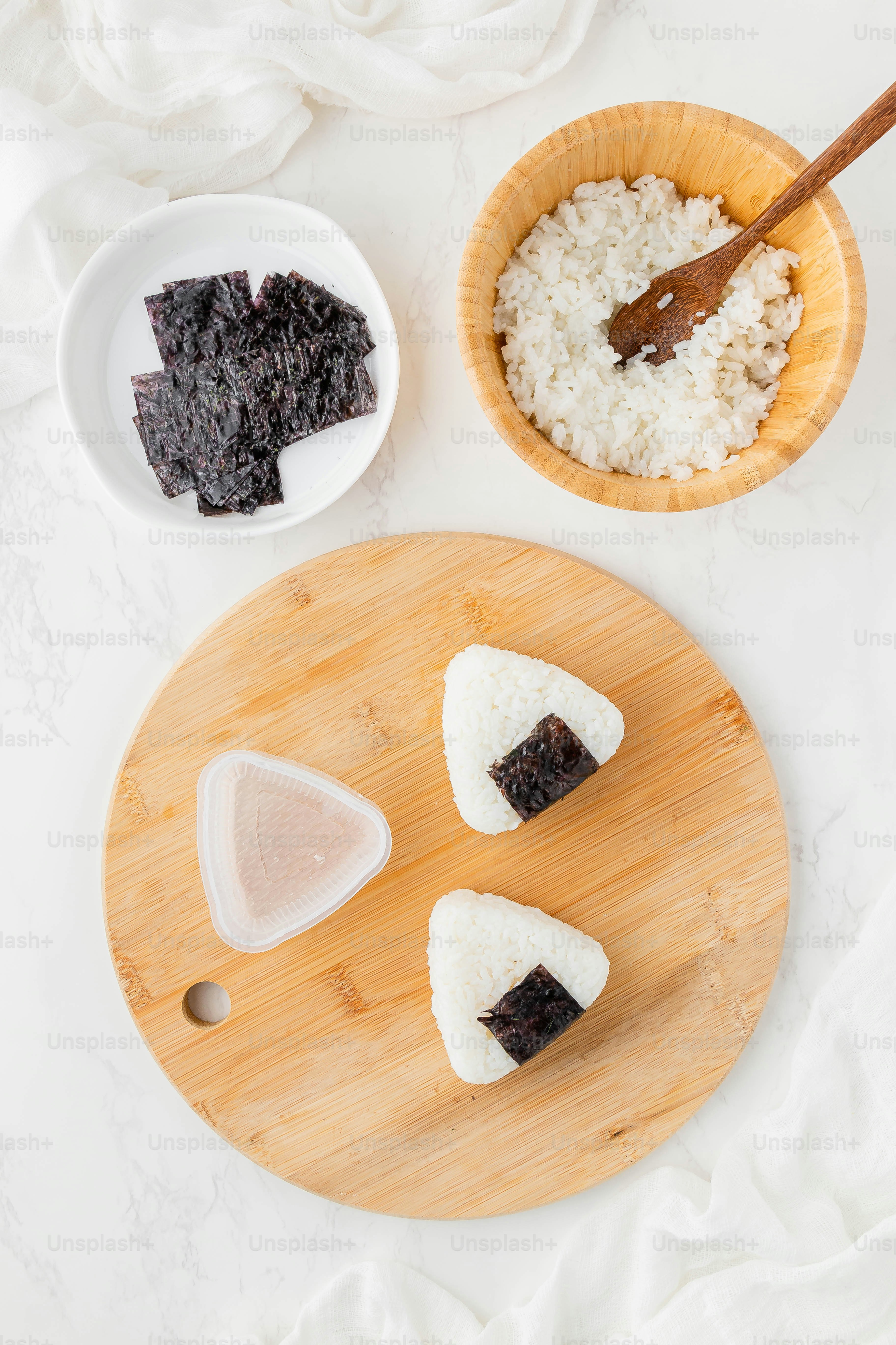 a cutting board topped with pieces of sushi next to a bowl of rice