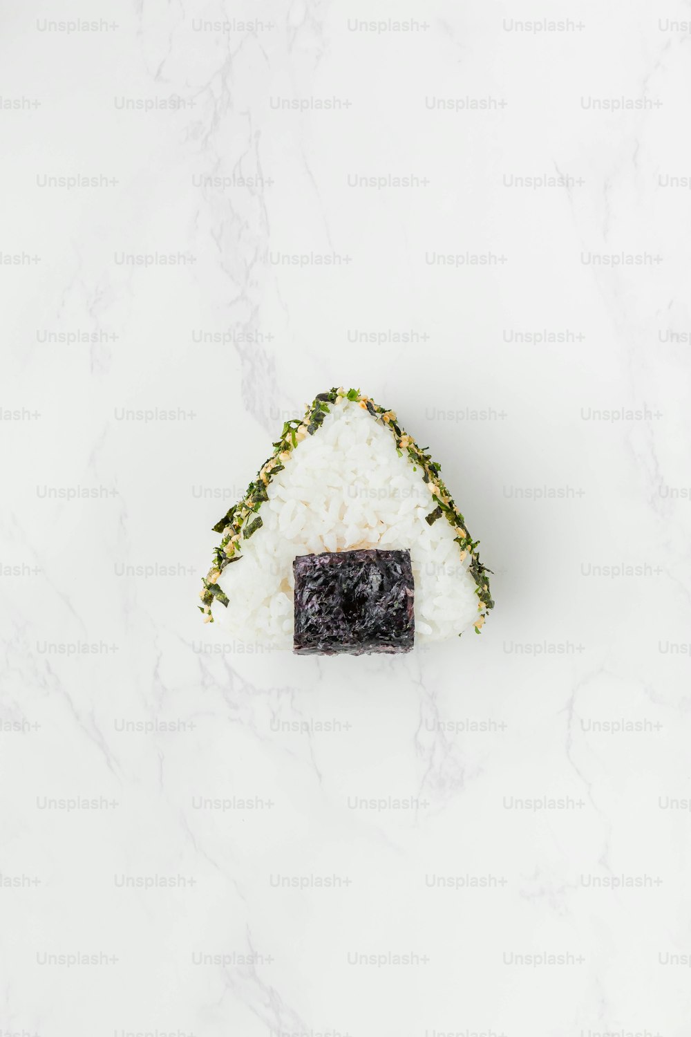 un pezzo di sushi seduto sopra il riso