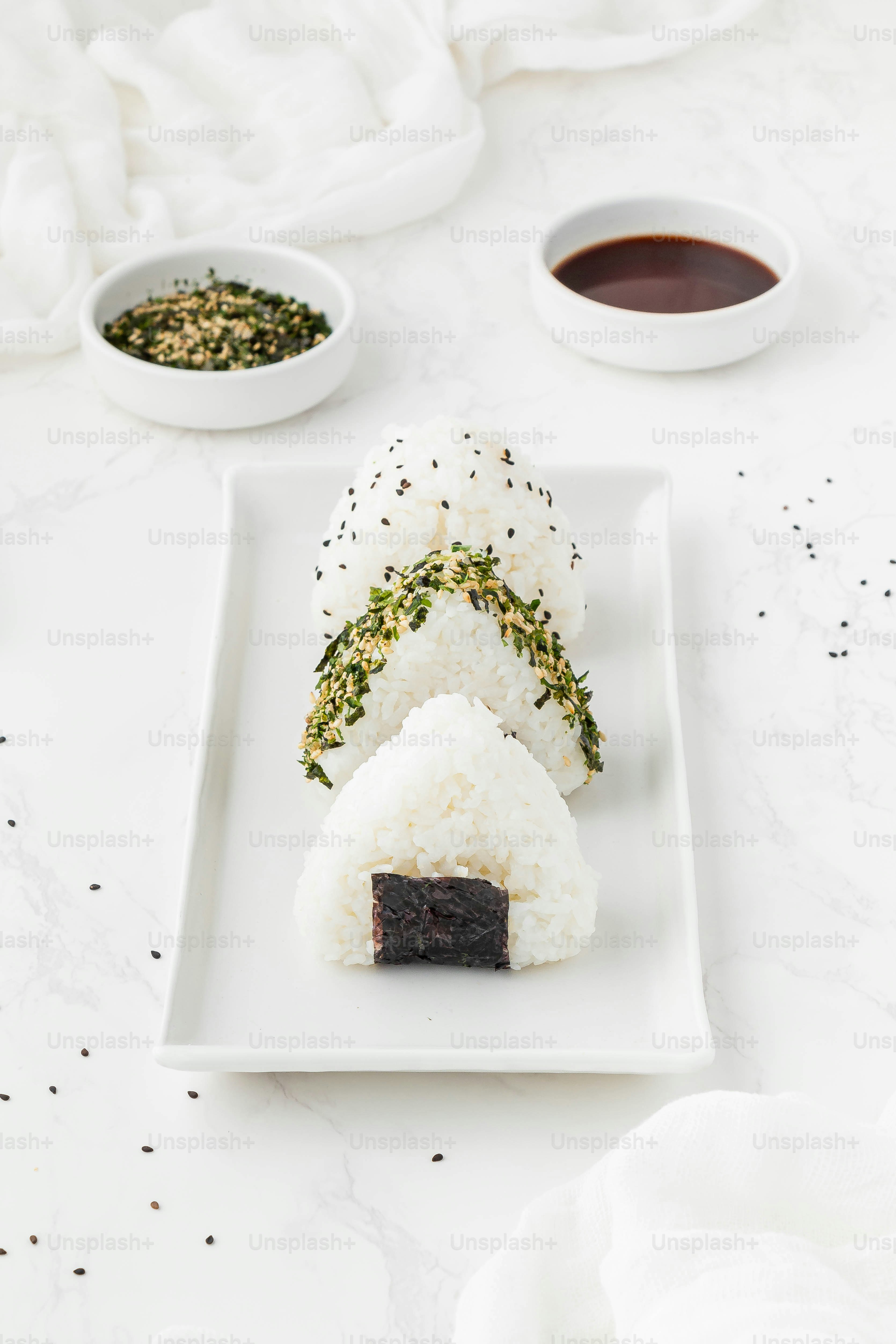 a white plate topped with sushi and sauce