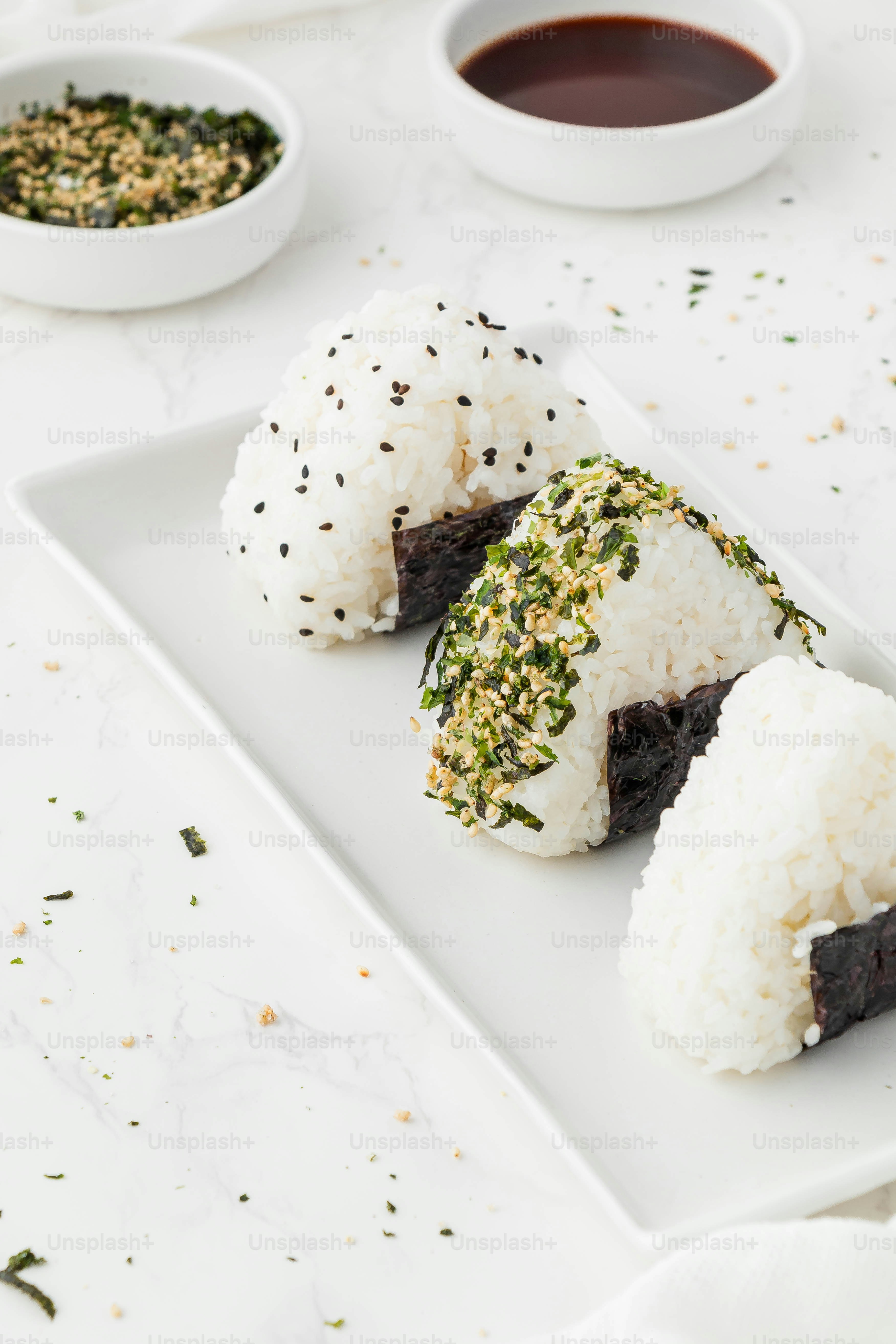 une assiette blanche garnie de sushis à côté d’un bol de sauce