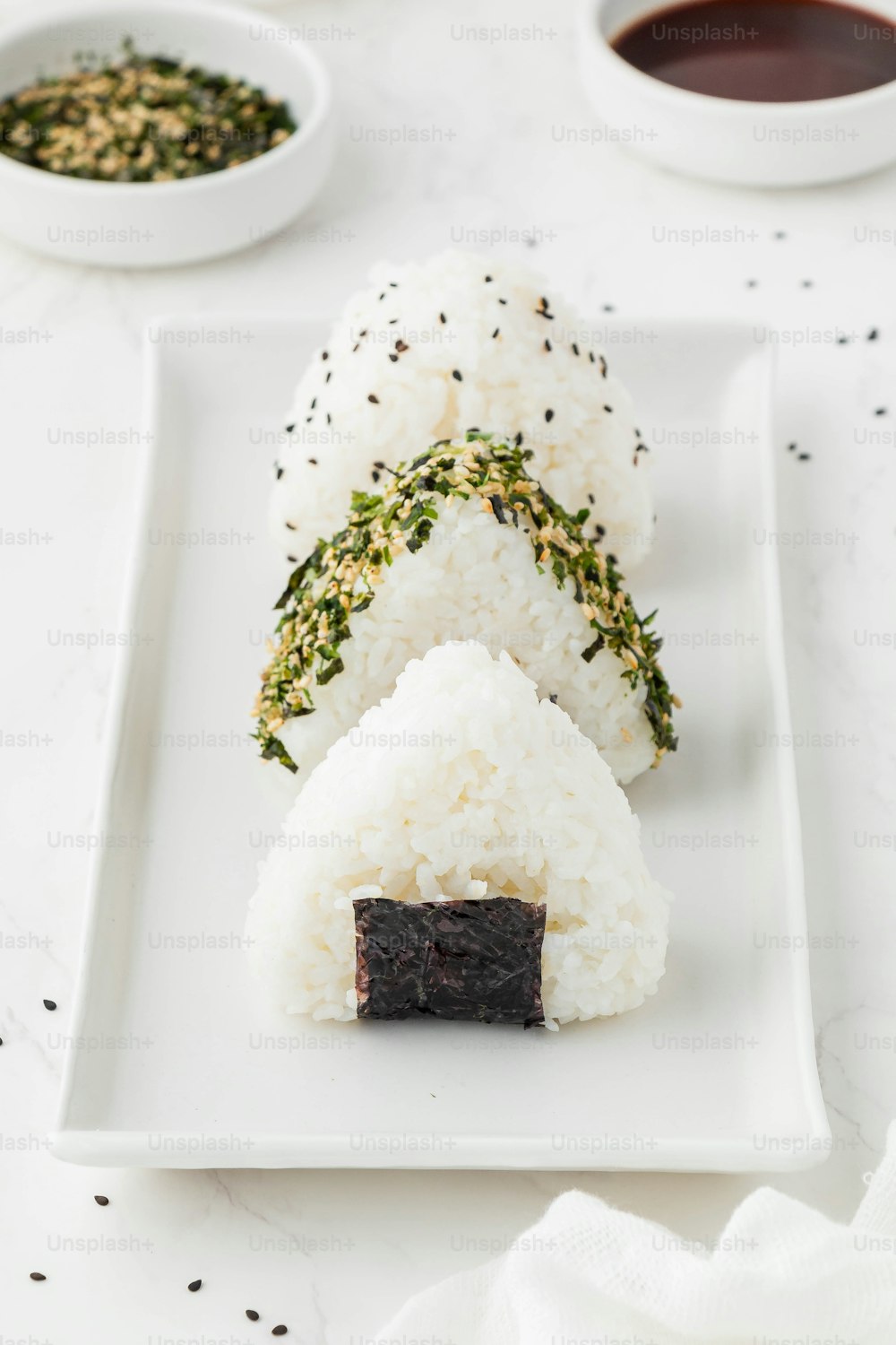 a white plate topped with rice covered sushi