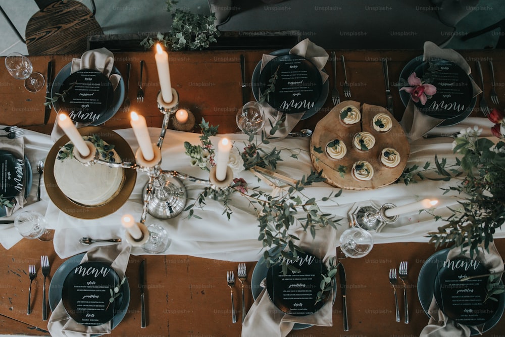 Una mesa cubierta con muchos platos y velas