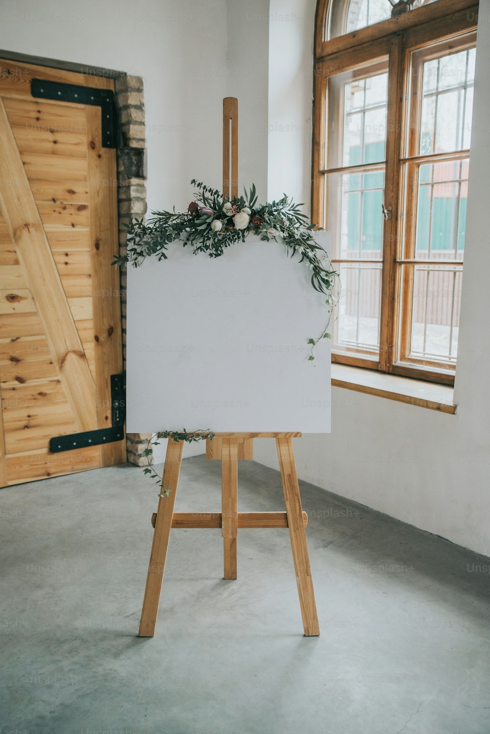an easel with a white board and flowers on it